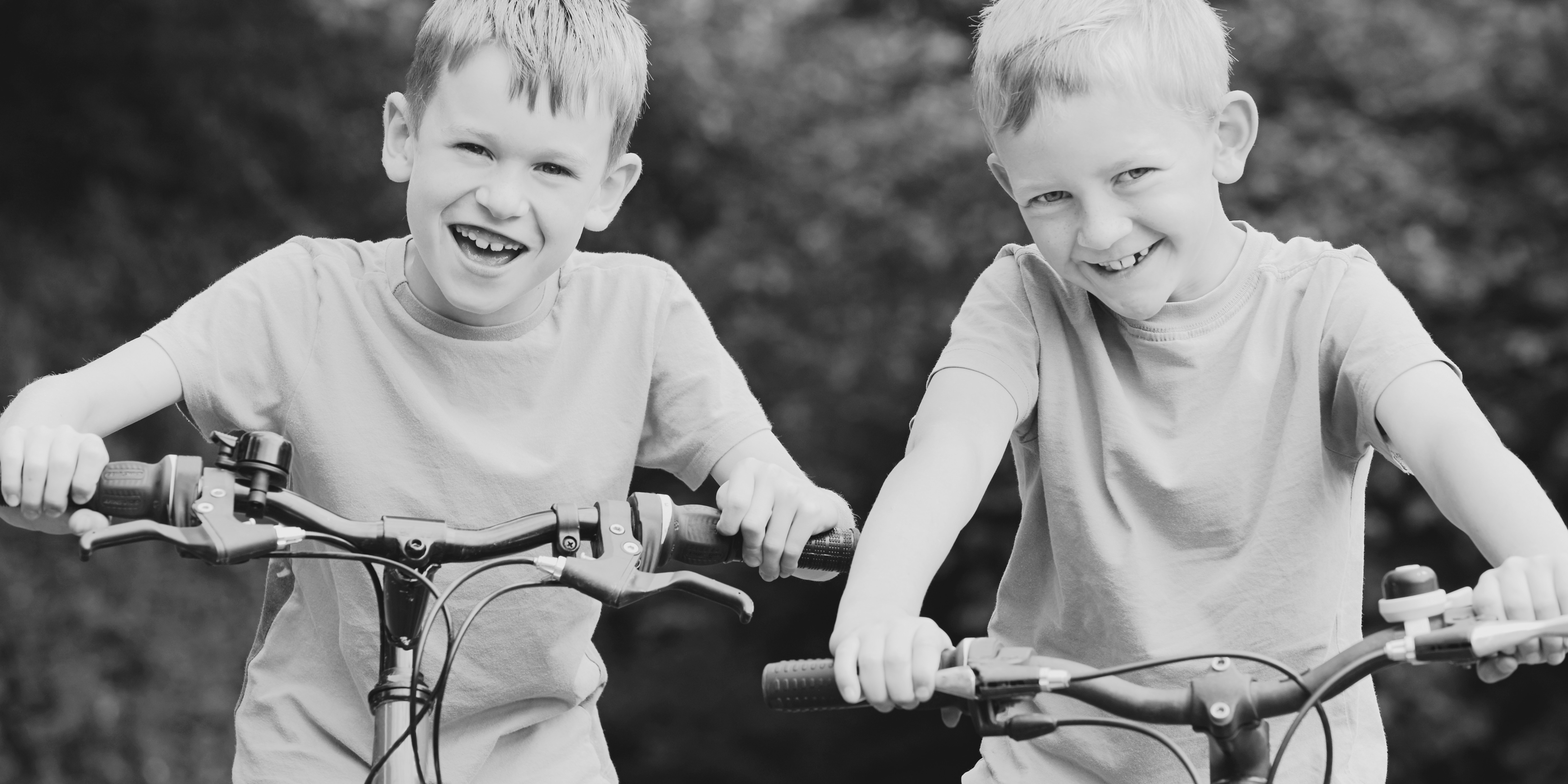 Two young brothers on a bicycles. 